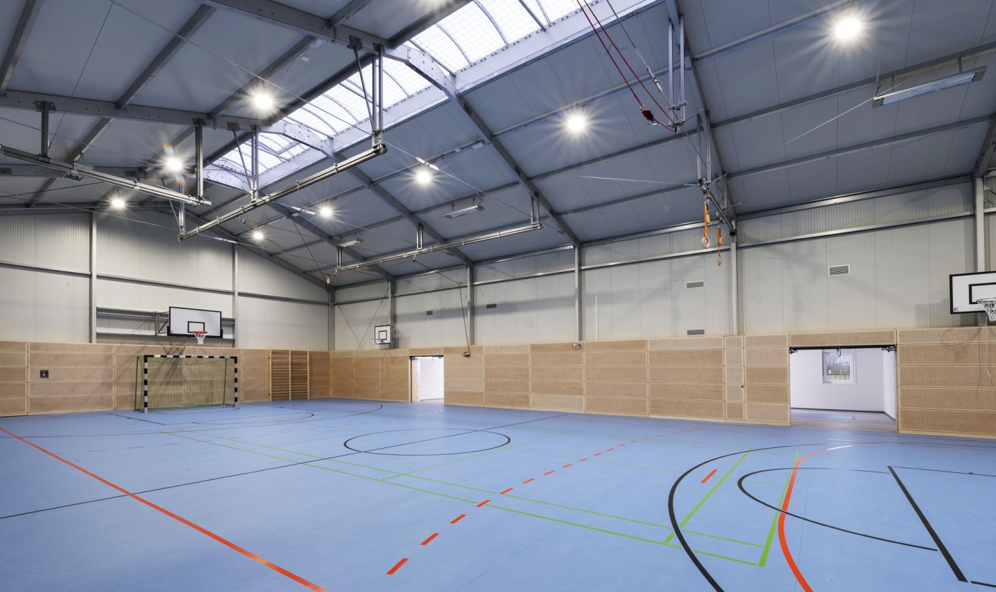 Interior of a modular sports hall with multi-use court and basketball equipment, built in Mainz-Finthen, Germany by Losberger De Boer.
