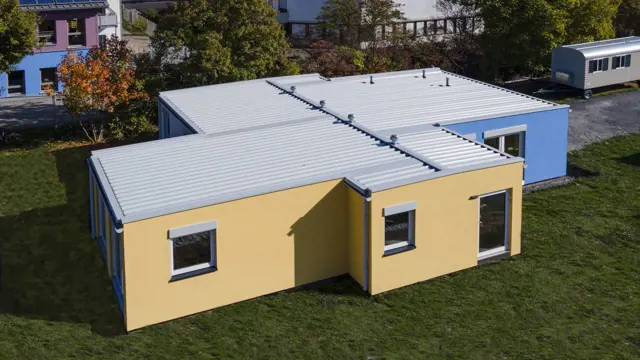 Luftaufnahme modularer Kindergarten mit blau-gelber Putzfassade Losberger Modular Systems