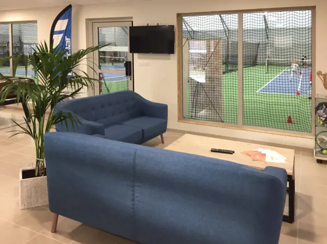 Club-house aménagé donnant sur court de tennis